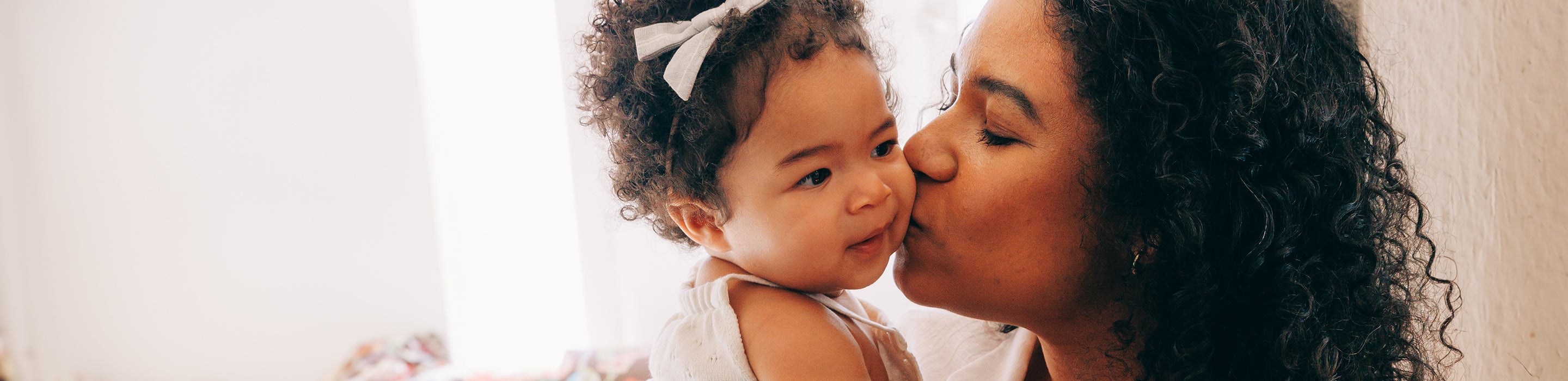 Mother kissing baby on cheek