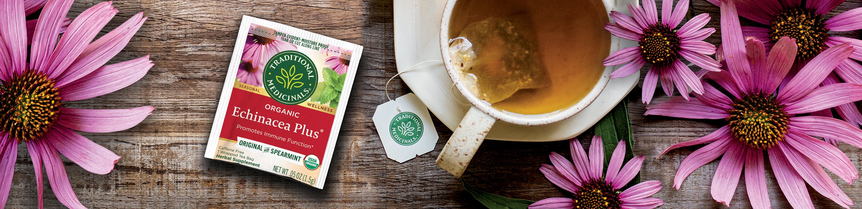 Echinacea Plus tea packet and brewed cup of tea with echinacea flowers on table