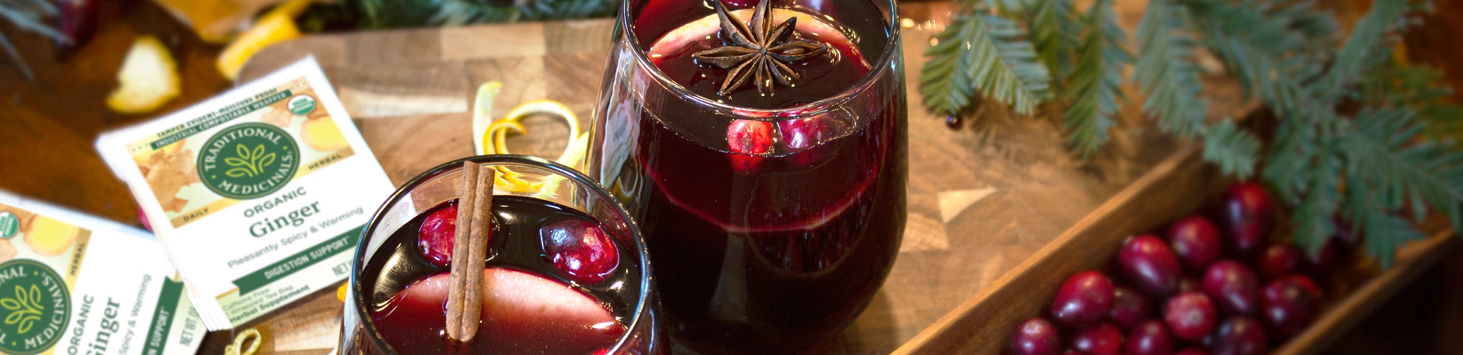 two glasses of spiced ginger mulled wine and tea bag packets on table