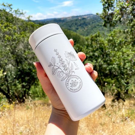 a hand holding a Traditional Medicinals Tea Tumbler