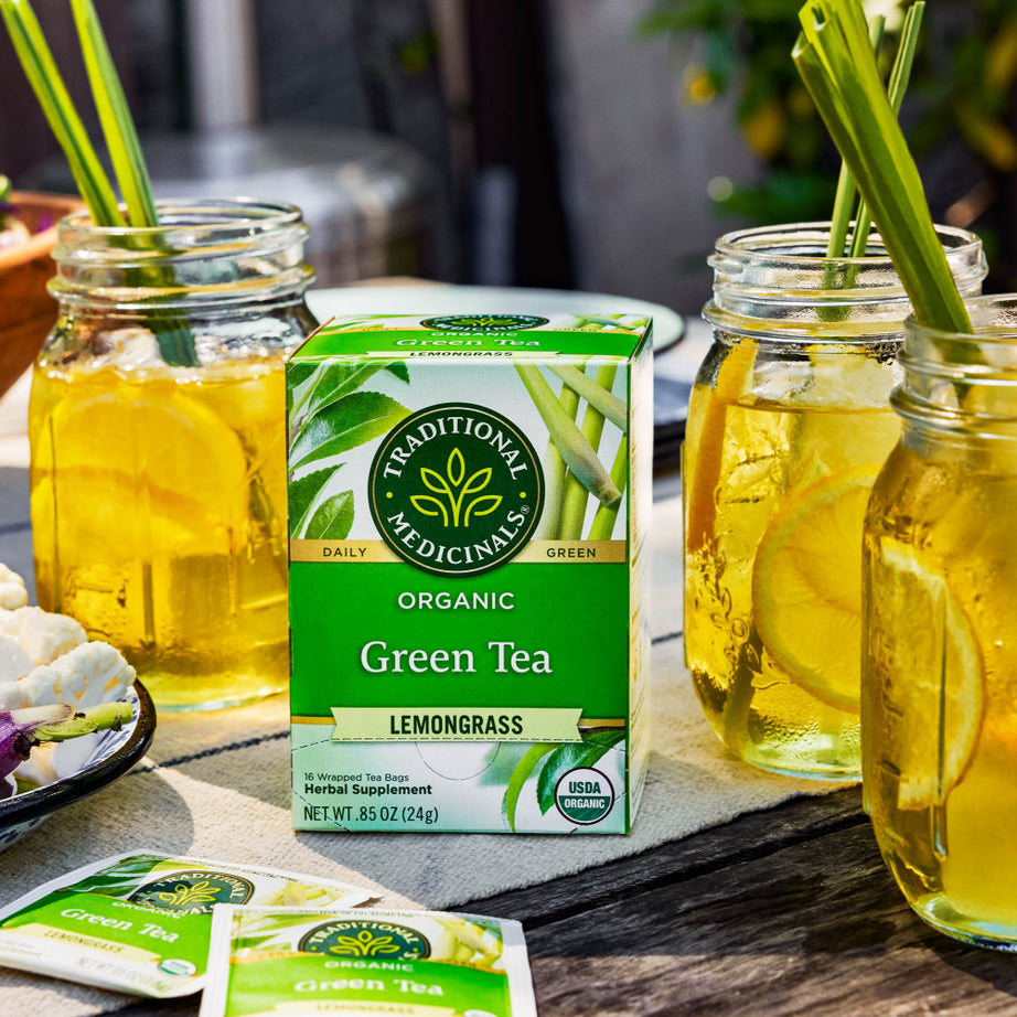 A box of Green Tea Lemongrass sits invitingly on the table, flanked by mason jars filled with refreshing iced tea and garnished with lemon slices.