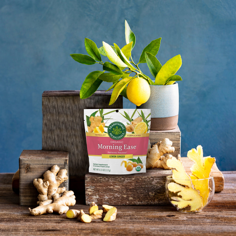 Pack of Morning Ease® Lemon Ginger Lozenges resting on a wooden surface against a blue background.